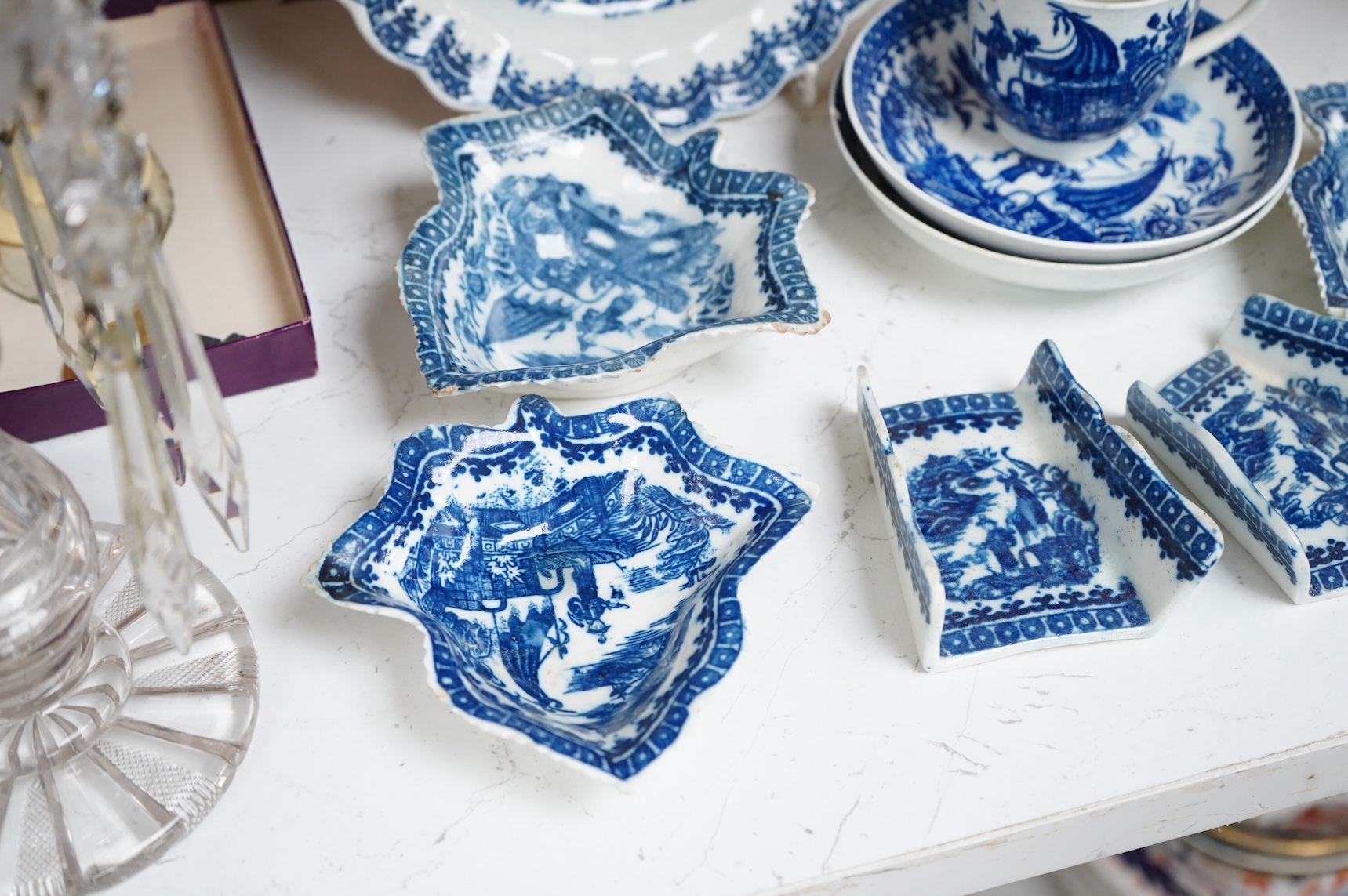 A group of 18th century Worcester or Caughley blue and white ‘Fisherman and Cormorant’ pattern wares; two asparagus dishes, three leaf pickle dishes, a cup and two saucers and a large dish- 18cm diameter (9).